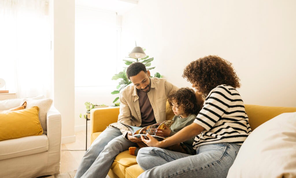 Family enjoying reading stories together on a cozy living room couch.