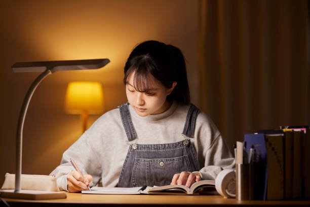 A high school girl studying for an exam in her room