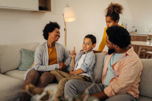 Parents and children sitting on sofa in the living room and socializing