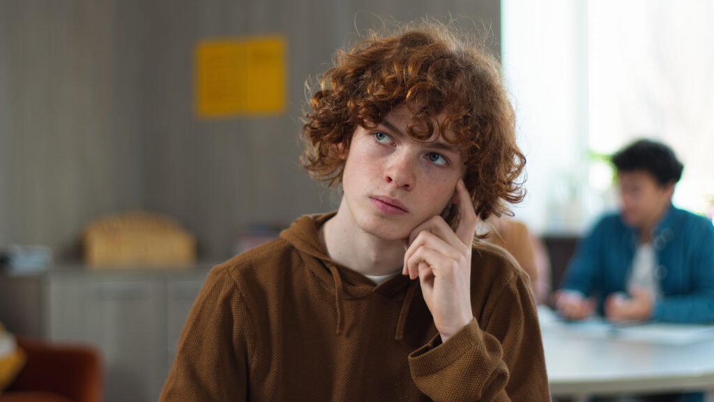 High school university teenagers education study pensive thinking Caucasian guy teen male boy schoolboy think student friends distract students throwing papers balls laughing playing crumpled paper