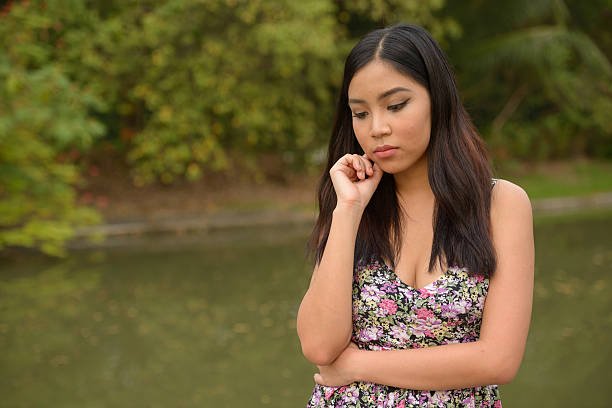 Portrait of Asian teenager girl thinking in park