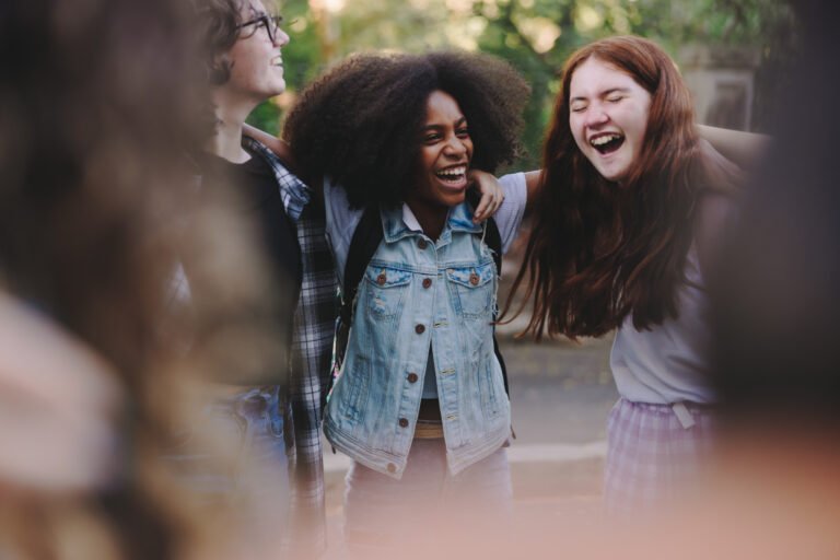 Happy teenage students standing together in a circle