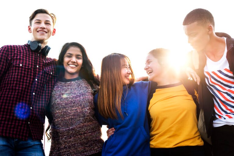 Group of school friends outdoors arms around one another togetherness and community concept