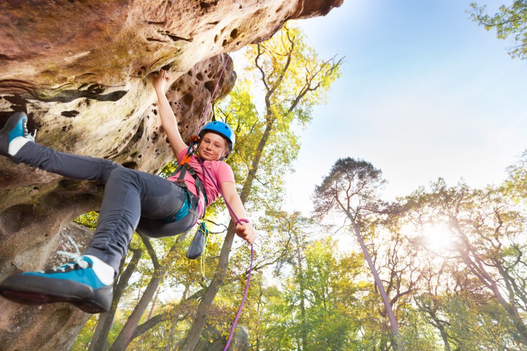 Rock climber exercising outdoors against blue sky