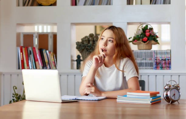 Pretty female student with a laptop in the libraries of University.