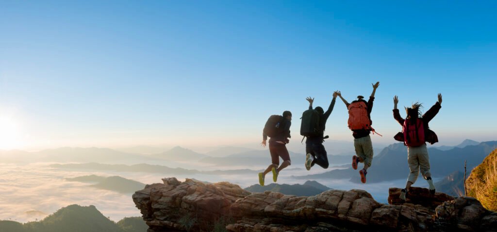 Group of happy hiker jumping on the hill