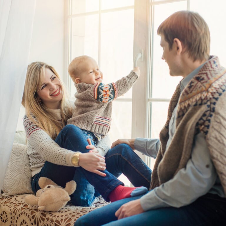 Happy family sitting in front of window in winter.