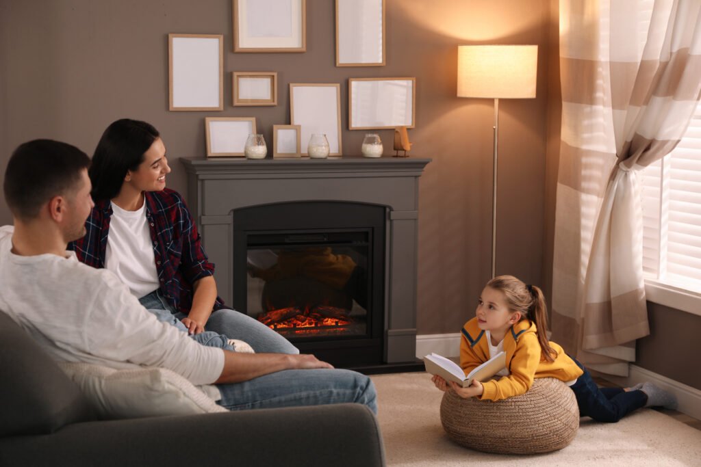 Happy family reading book together near fireplace at home
