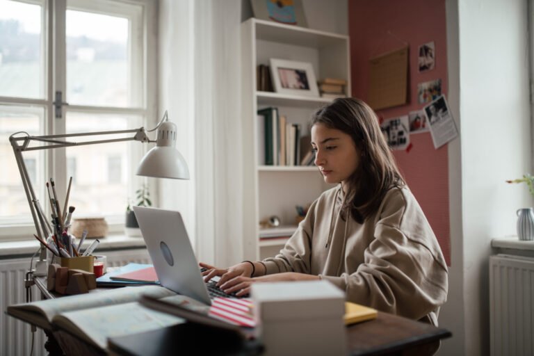 Young teenage girl studying in her room.