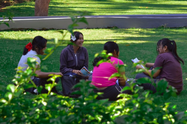 Friends having lively conversation with books outdoors