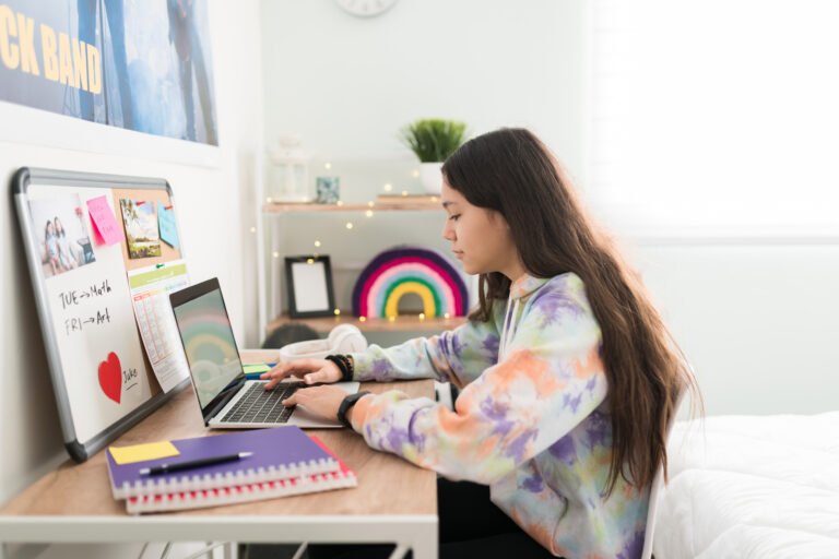 Side view of a teen girl doing school work in her desk