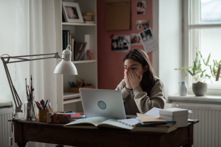 Young teenage girl studying in her room.