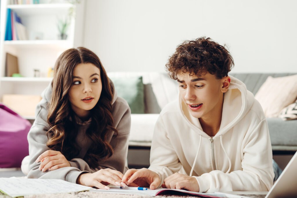 Teenagers doing homework together at home, learning and studying