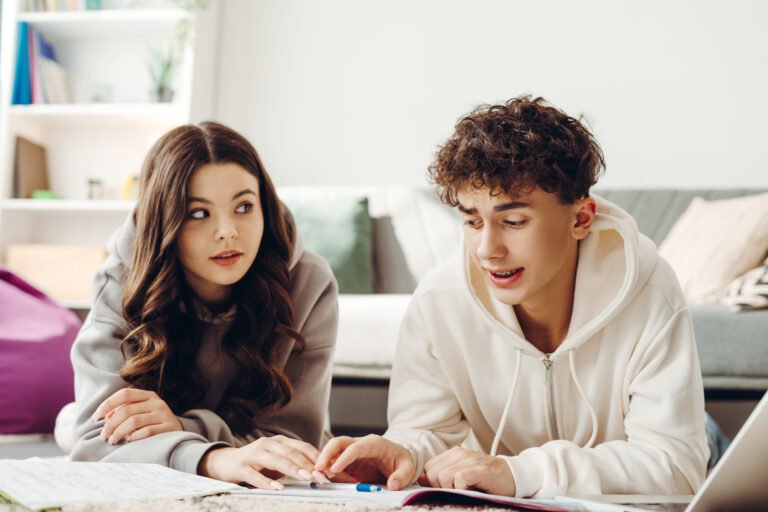 Teenagers doing homework together at home, learning and studying