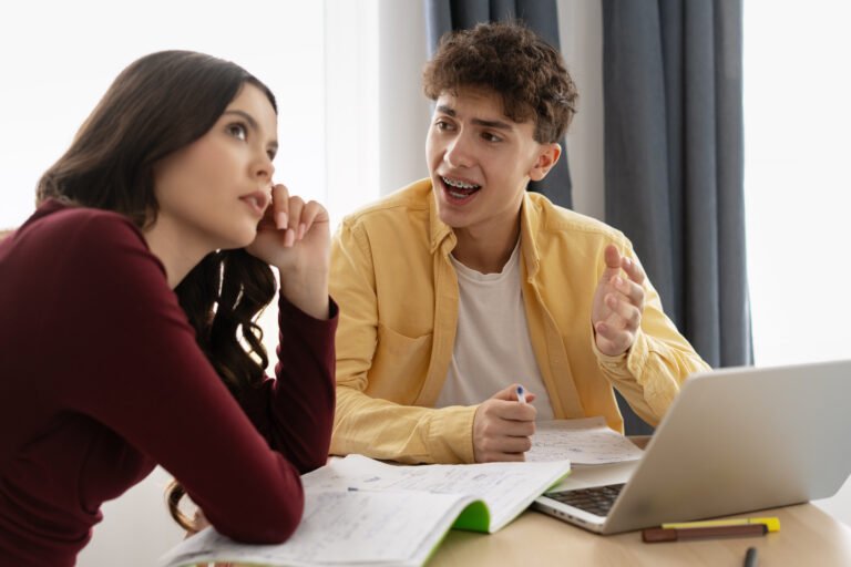 Students discussing and learning together with laptop and notebook