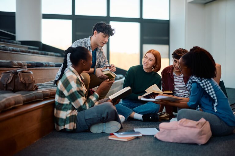 Young happy college friends studying together in lecture hall.