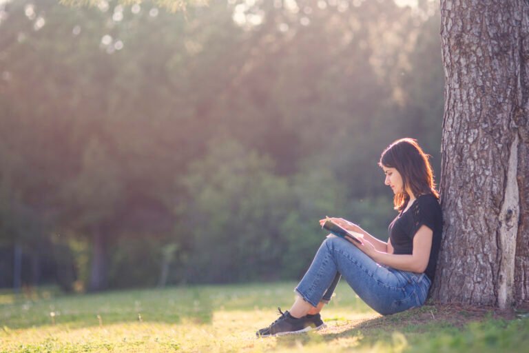Girl reading book under a tree