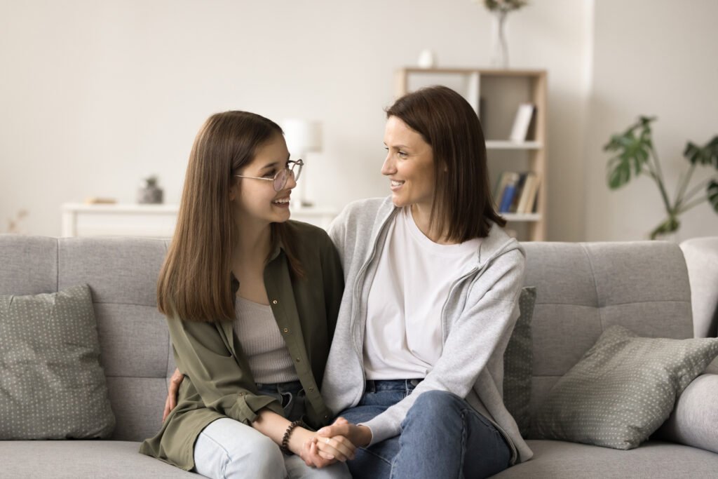 Positive mom and teenager kid enjoying conversation, friendship
