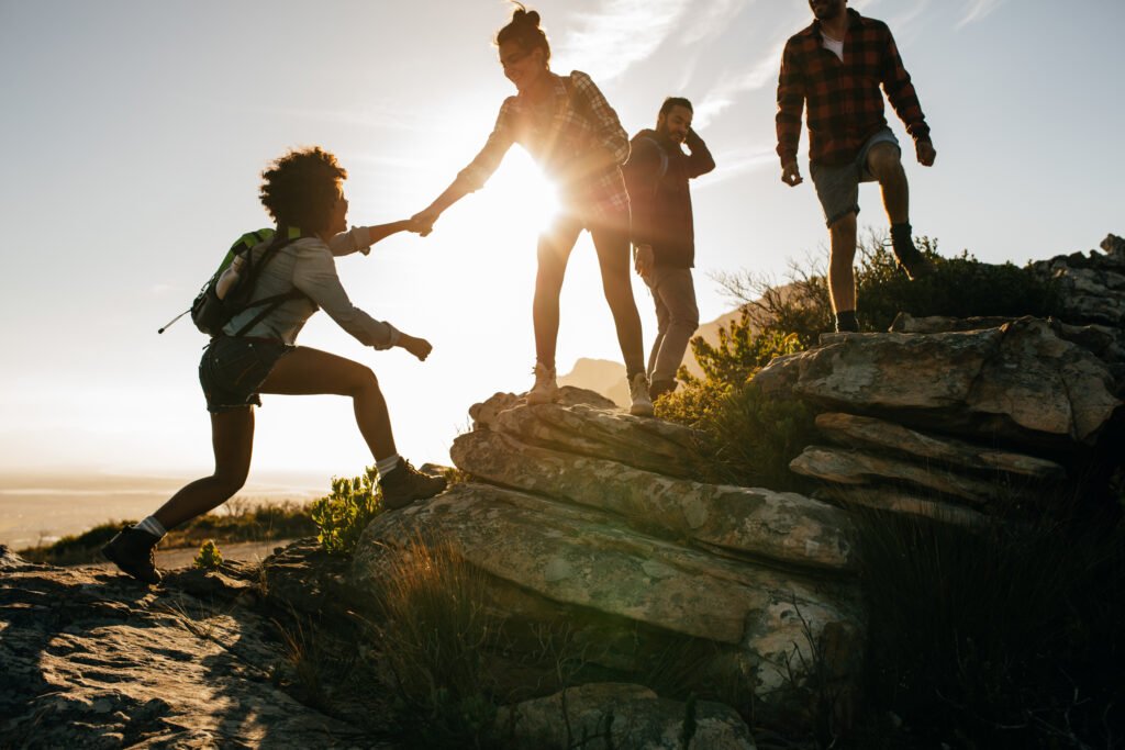 Young people on mountain hike at sunset