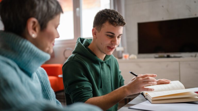 One student teenage caucasian man study learn with help of his tutor professor or mother senior woman at home having private lesson to prepare for exam education concept real people copy space