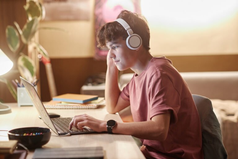 Teenage Boy Using Laptop with Headphones