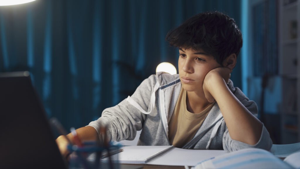 Teenager watching online classes at night