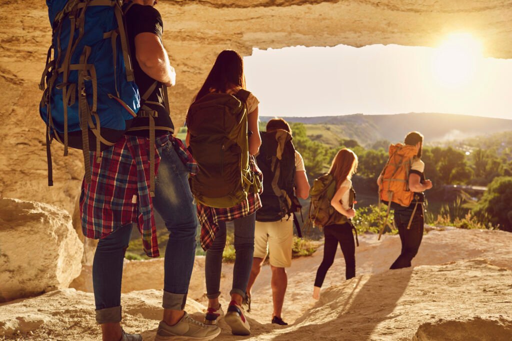 Group of travelers hikers hiking in natural mountaints outdoors with great landscape ahead