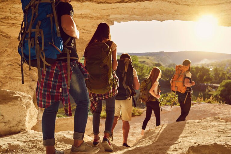 Group of travelers hikers hiking in natural mountaints outdoors with great landscape ahead
