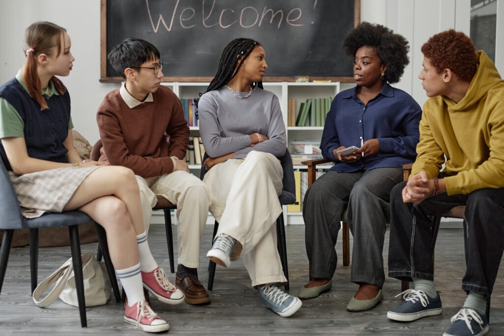 Diverse Group of Children with Therapist Sitting on Chairs in Circle