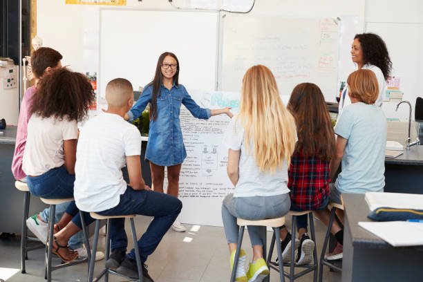 Schoolgirl presenting in front of science class, close up