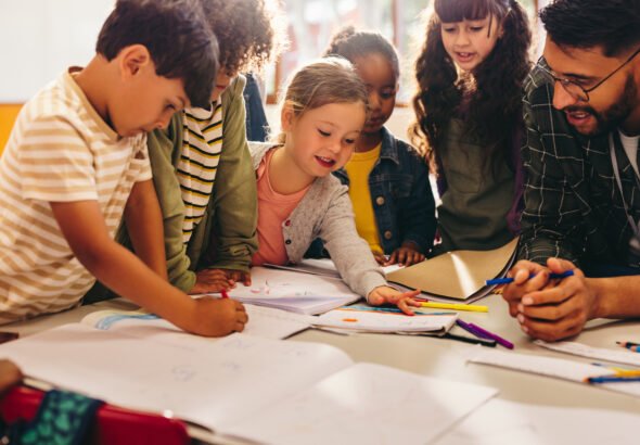 Group of children doing an art project with their teacher